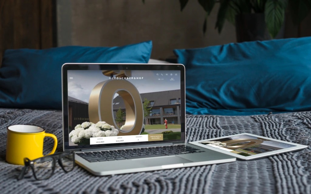 Laptop and table laying on a web showing the home page of the website