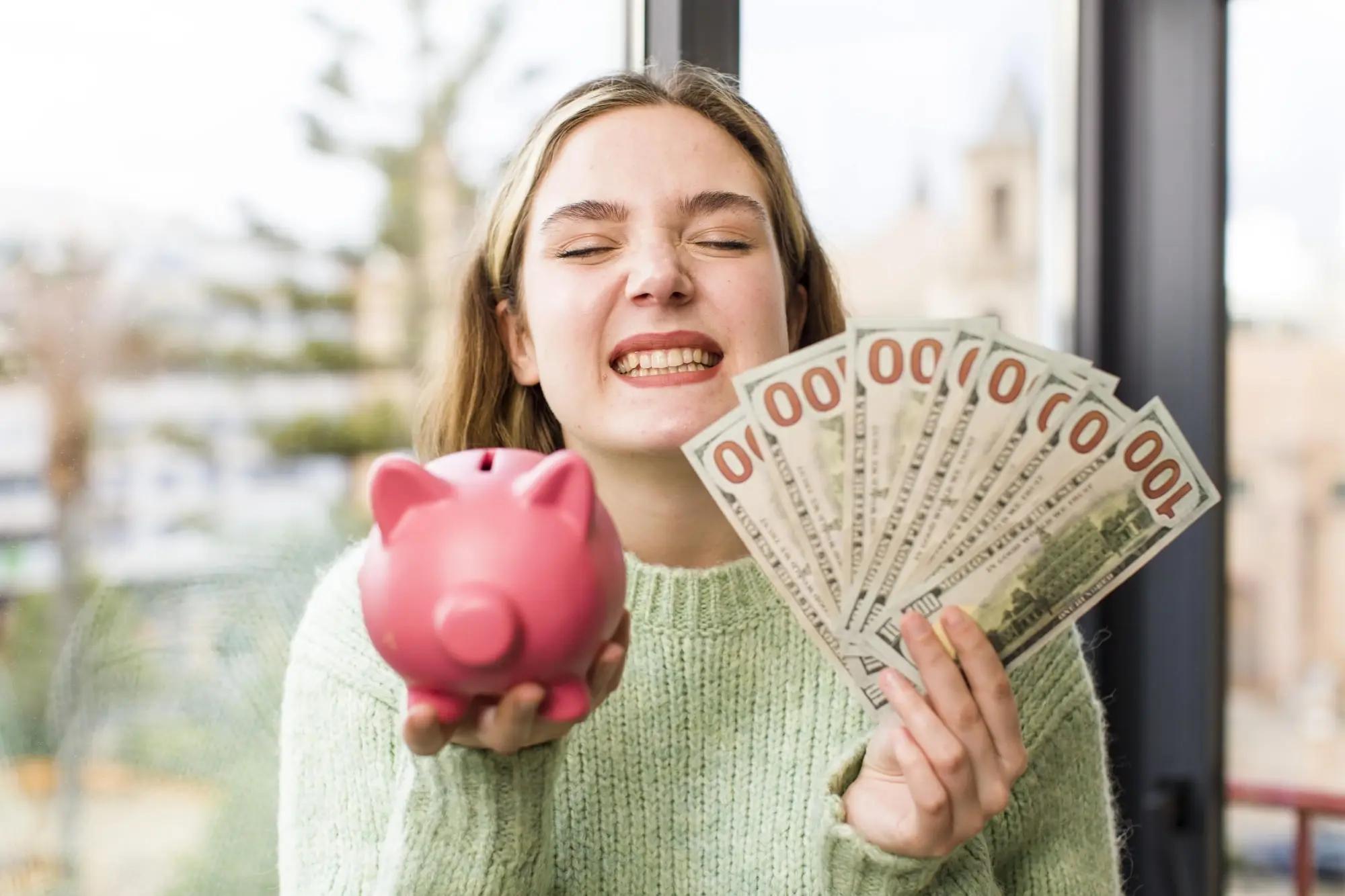Woman holding a savings pig and saved money in her hands